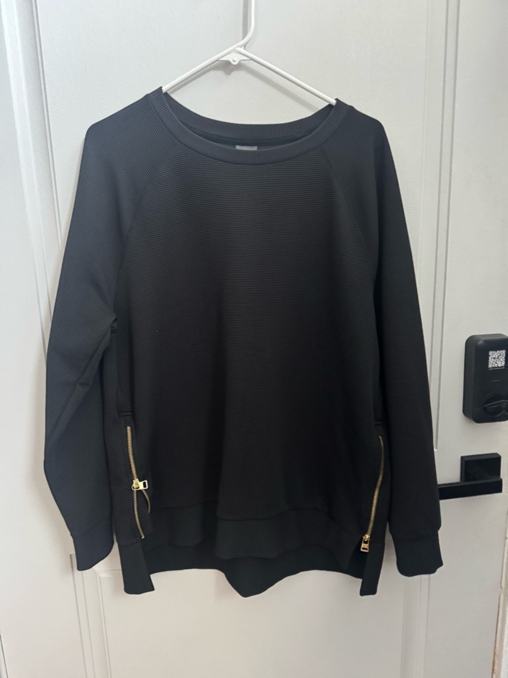 Black long sleeve ribbed shirt with gold zipper accents